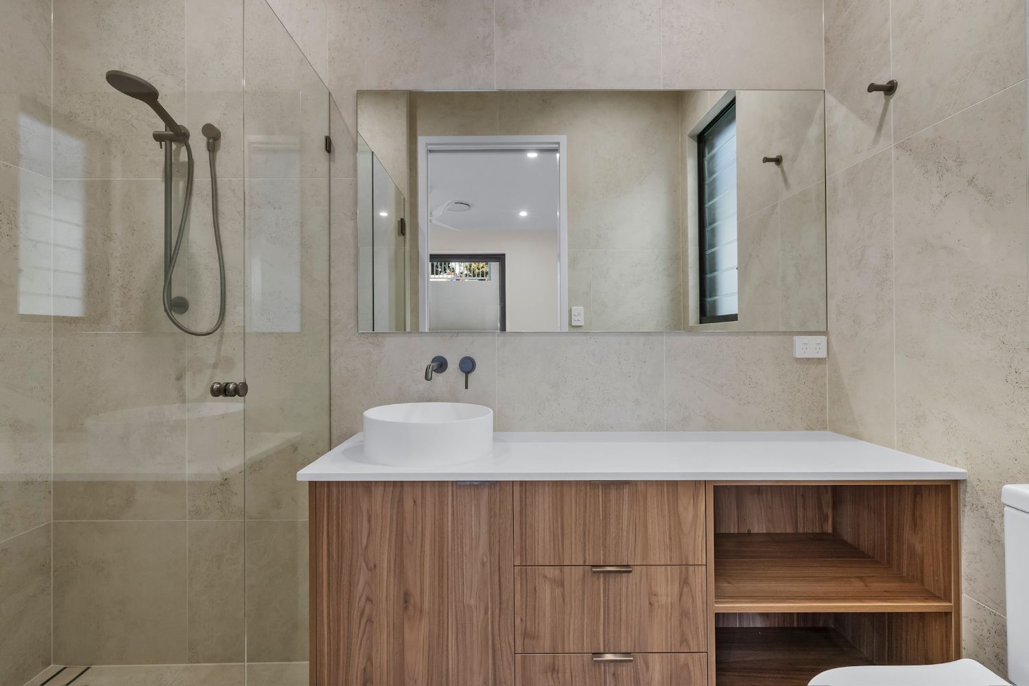 Vanity with vessel basin, wall-mounted mixer and frameless shower